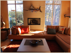 Large windows flood the living area with light and appear to bring nature indoors.
