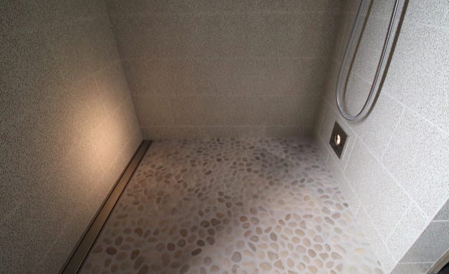shower river rock pebble flooring with low lighting